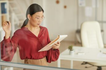 Asian Businesswoman Writing on Glass in Office