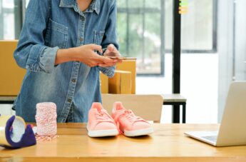 Online sellers use mobile phone to take pictures of shoes sent to customers.