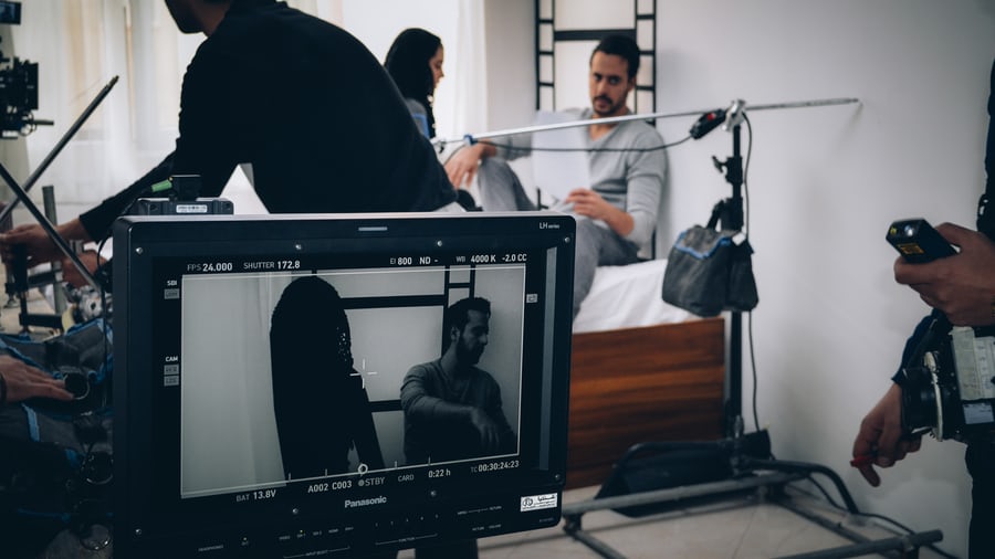 A group of people doing a photoshoot in a white room and editing images.