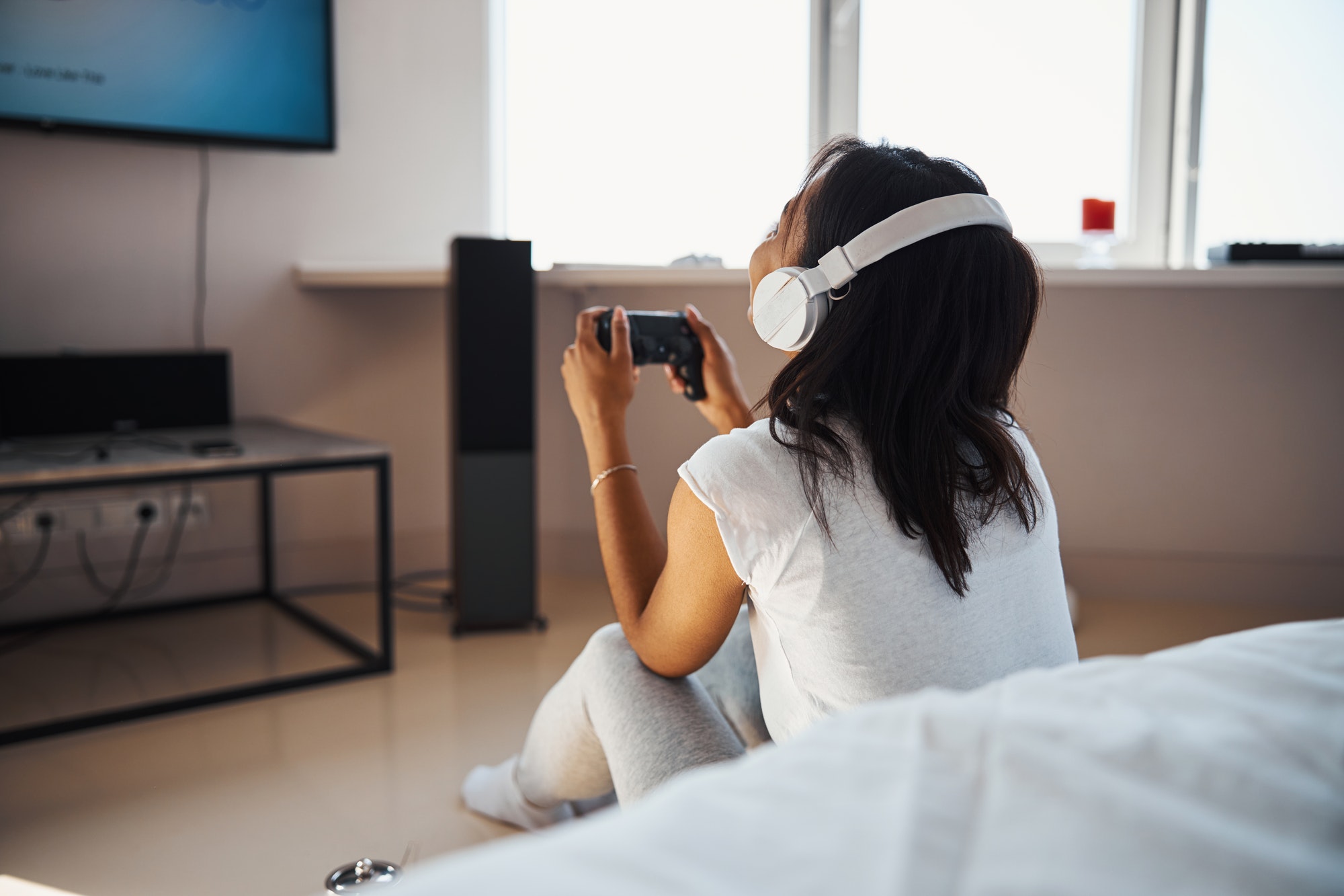 PickFu mobile gaming poll: woman in headphones playing video game at home