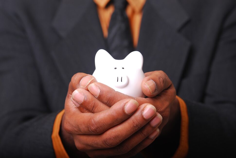 a pair of hands holding a piggybank