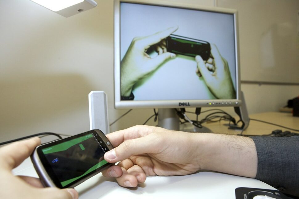 image-of-a-man-holding-a-phone-and-doing-a-mobile-usability-test