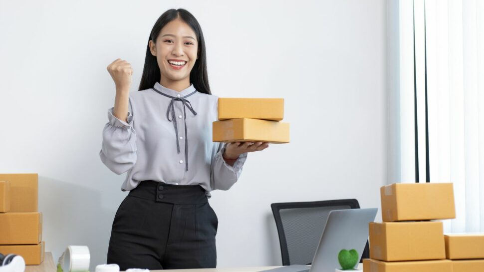 Amazon-seller-happy-she's-sold-more-products-with-two-boxes-in-her-hand